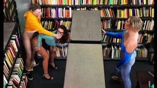 A Brunette With Glasses Gave A Cap To A Student In The Library