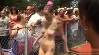 Large-breasted models pose and dance at an outdoor party